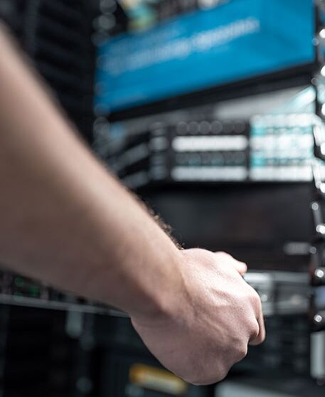 Hand an einem Serverrack im laufenden IT-Betrieb